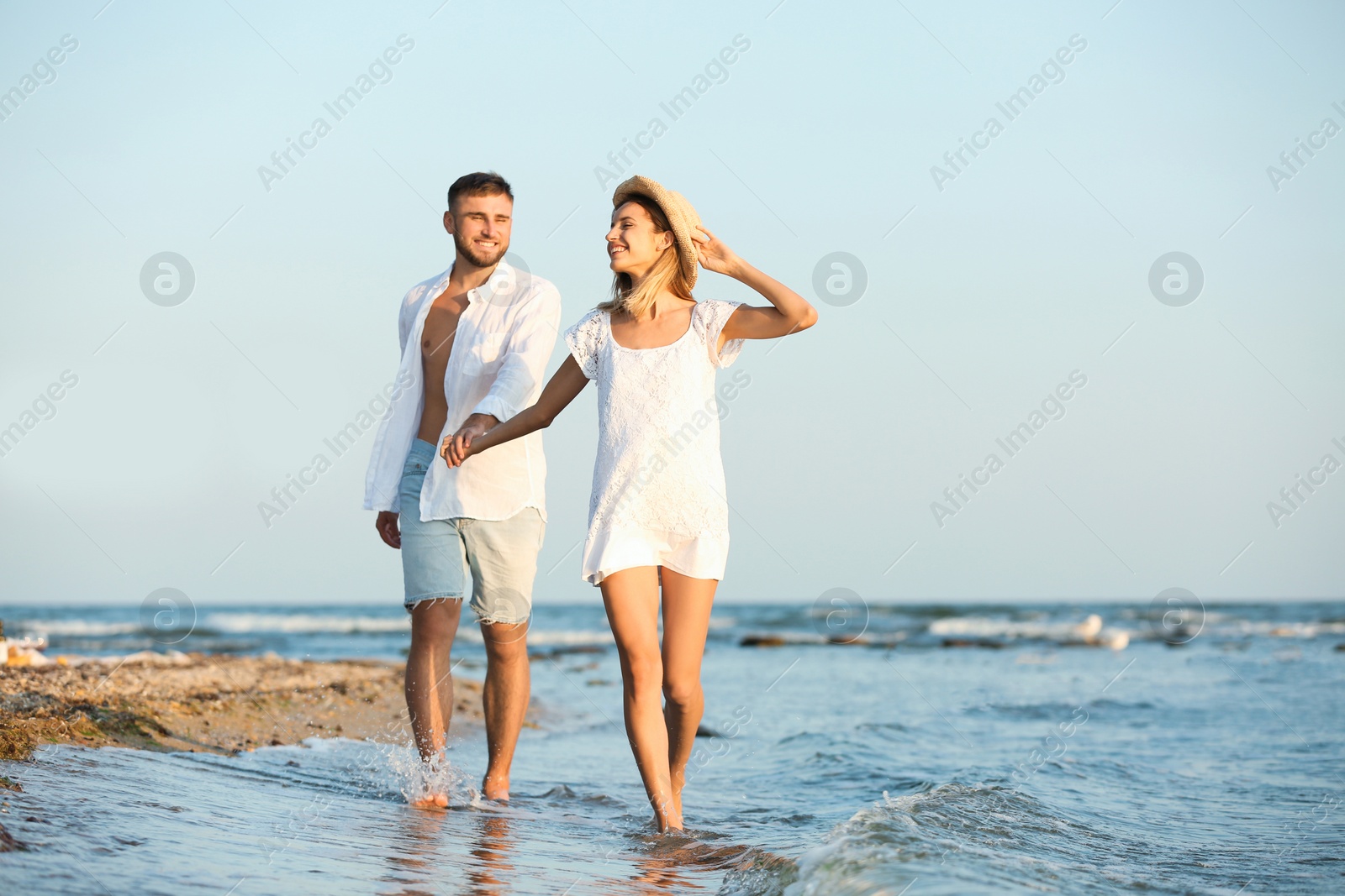 Photo of Young couple spending time together on beach