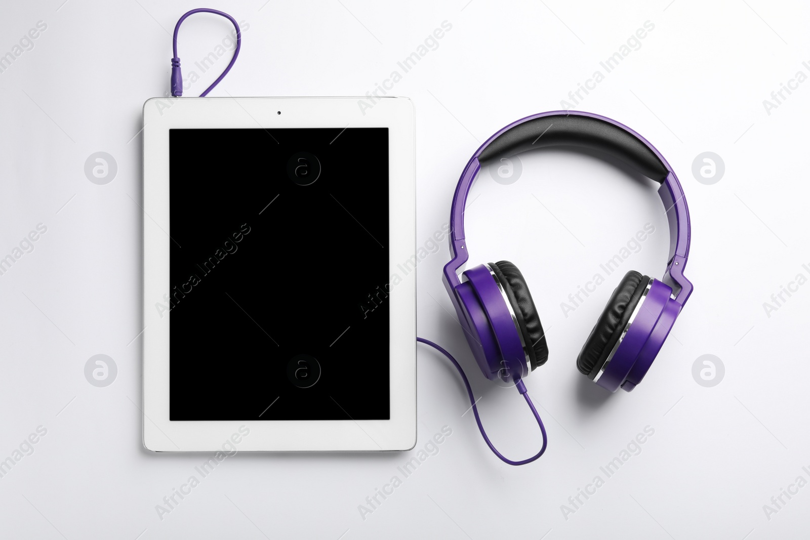 Photo of Stylish headphones and modern tablet on white background, top view. Space for text