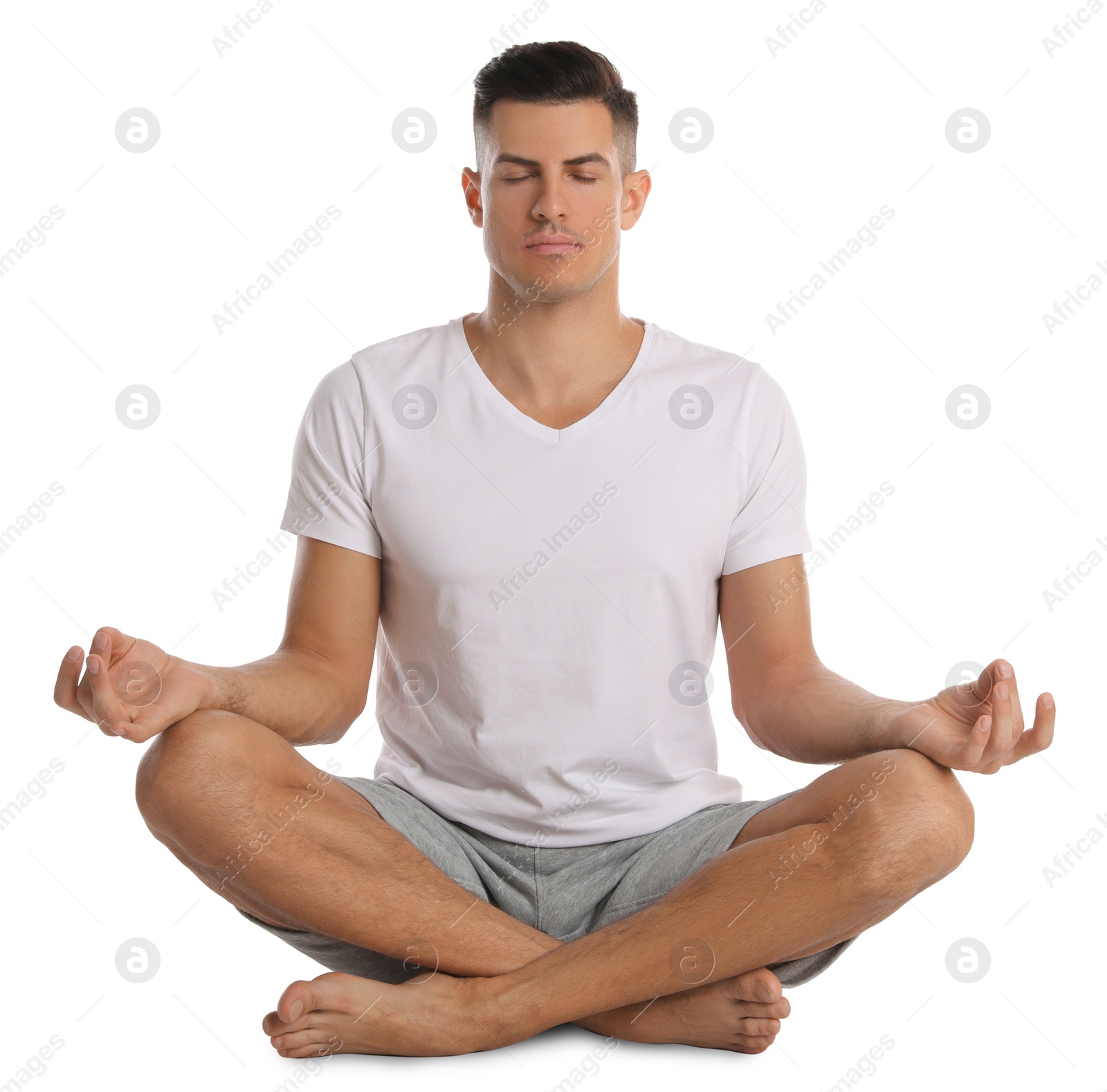 Photo of Handsome man meditating on white background. Harmony and zen