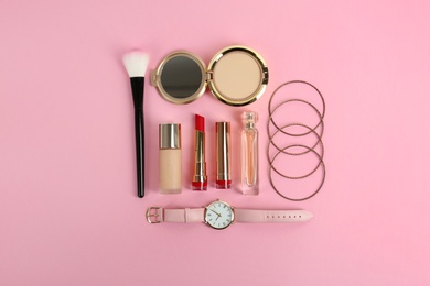 Flat lay composition with bright lipstick and accessories on pink background