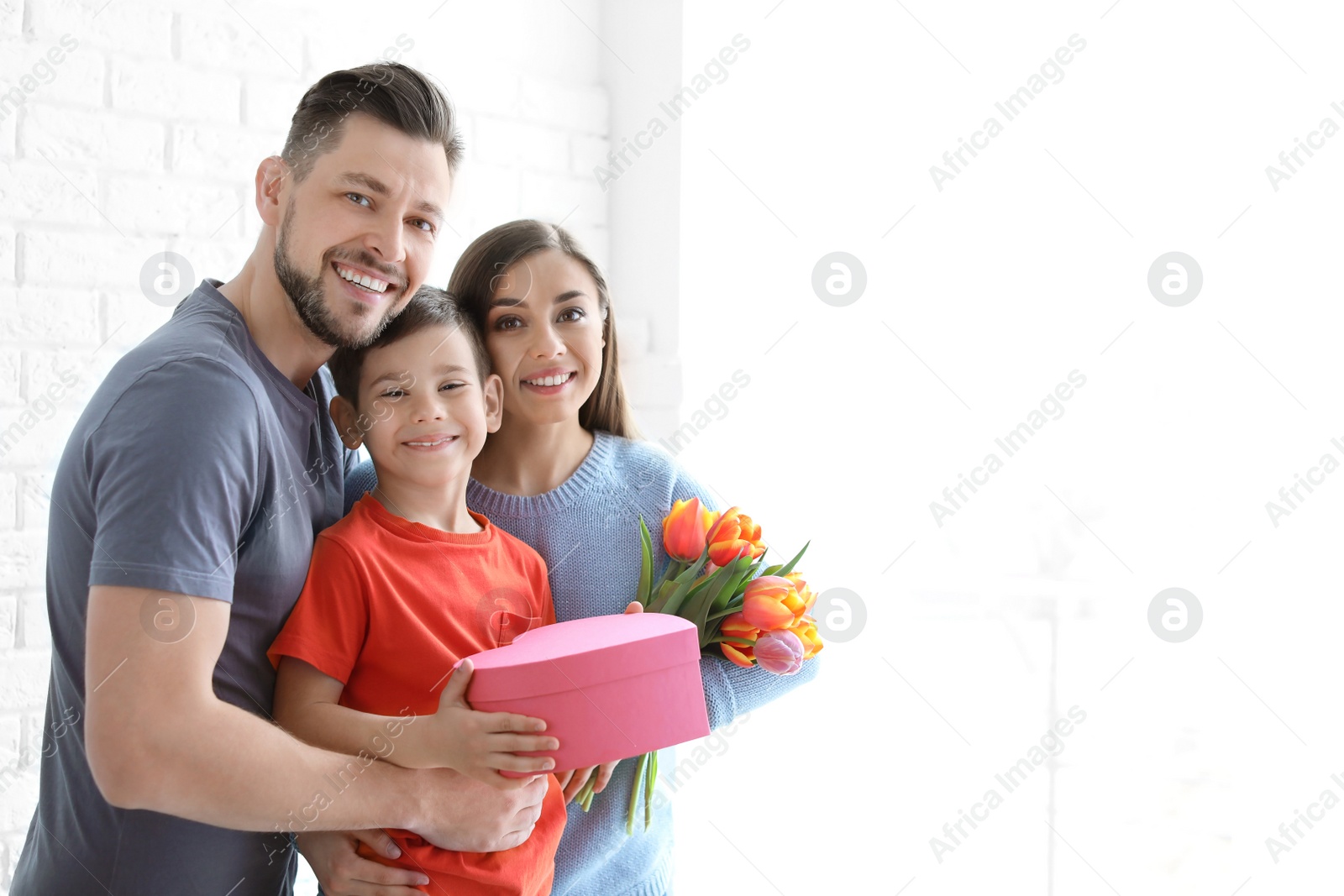 Photo of Portrait of happy family with gifts on light background. Mother's day celebration