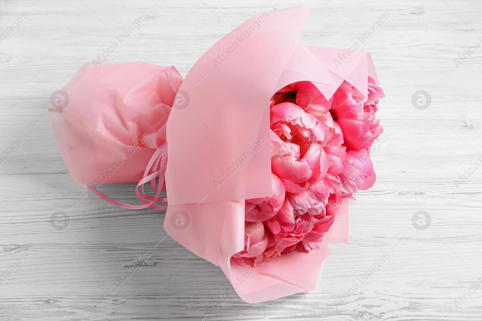 Photo of Bouquet of beautiful pink peonies on white wooden table