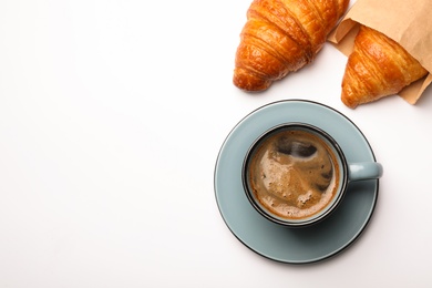 Photo of Cup of coffee and croissants on white background, flat lay. Space for text