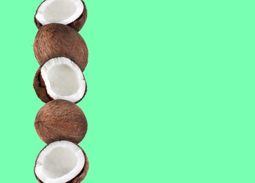 Stack of fresh coconuts on pale light green background. Space for text