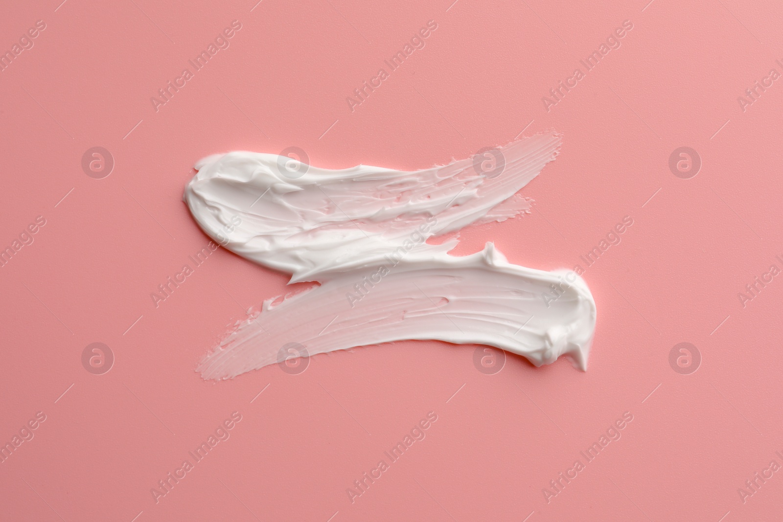 Photo of Sample facial cream on pink background, top view