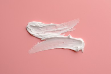 Photo of Sample facial cream on pink background, top view