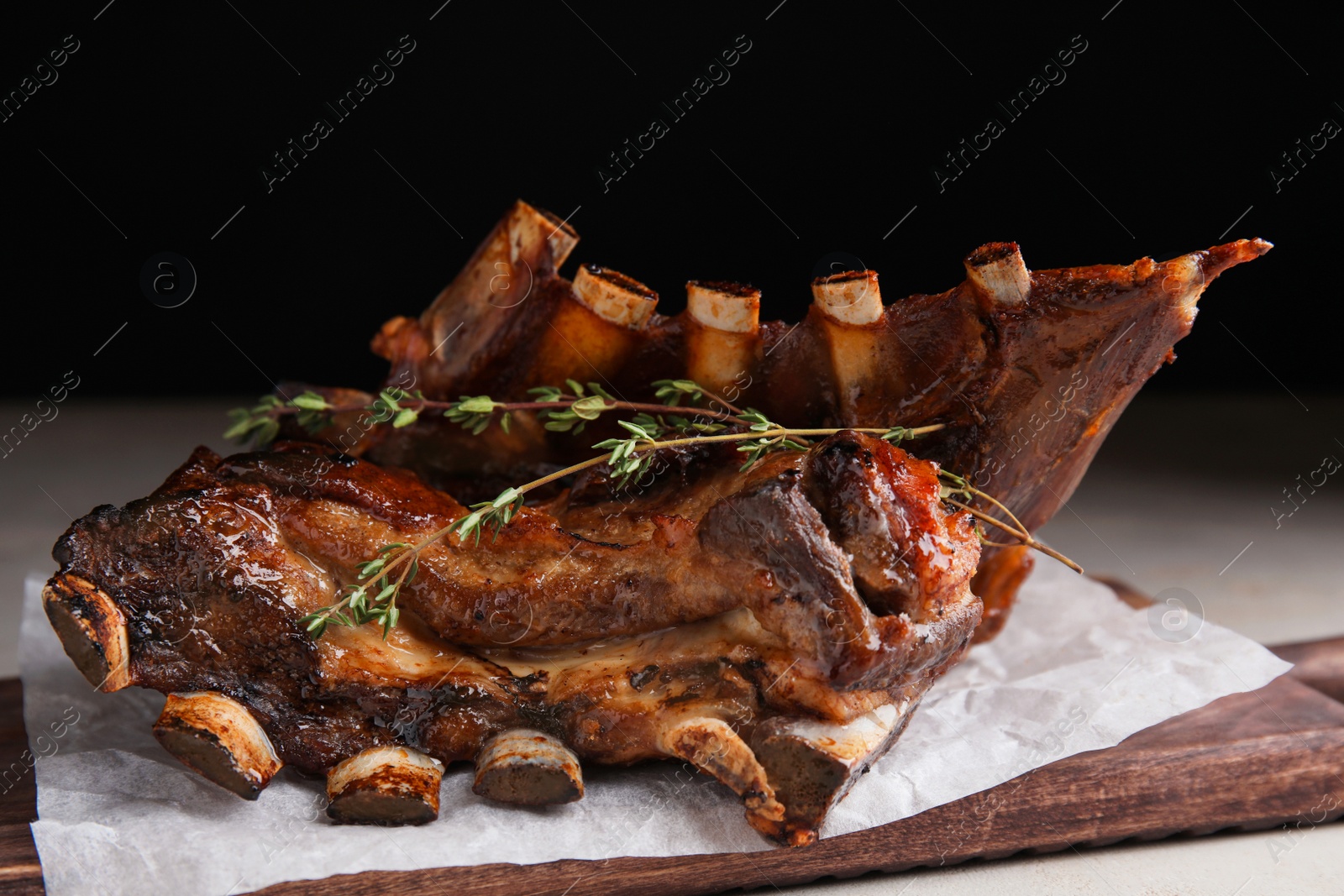 Photo of Delicious roasted ribs served on table, closeup