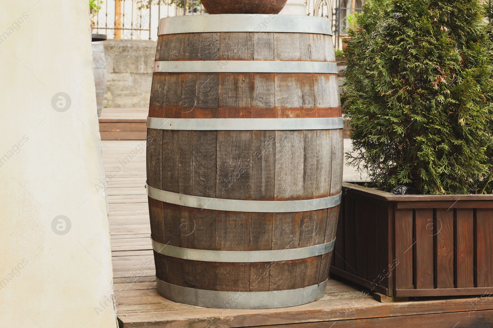 Photo of Traditional wooden barrel on street outdoors. Wine making