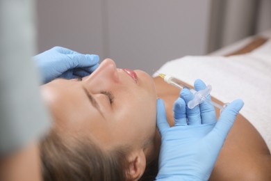 Beautiful woman getting facial injection in salon