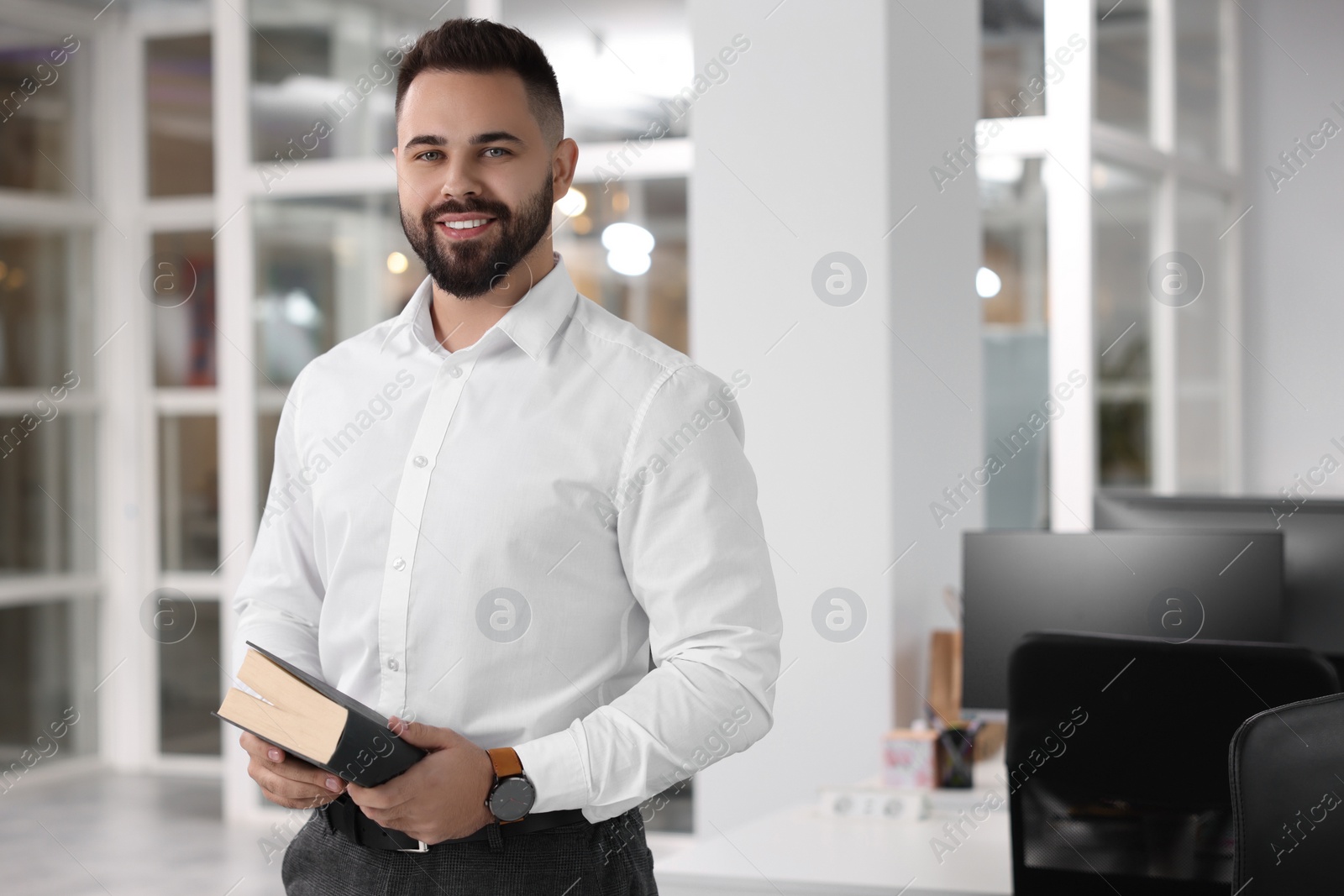 Photo of Portrait of smiling man with book in office, space for text. Lawyer, businessman, accountant or manager