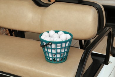 Photo of Green basket with golf balls on car seat outdoors