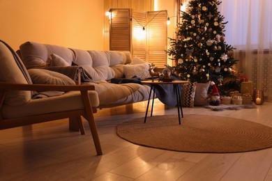 Photo of Beautiful room with sofa and tree decorated for Christmas. Interior design