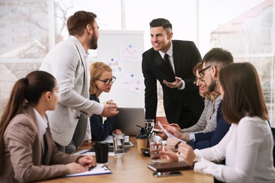 Photo of Businesspeople having meeting in office. Management consulting