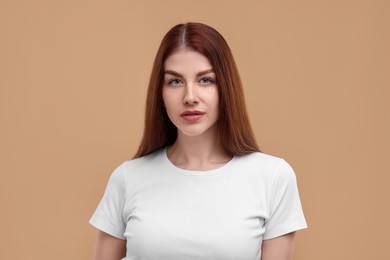 Portrait of beautiful woman with freckles on beige background