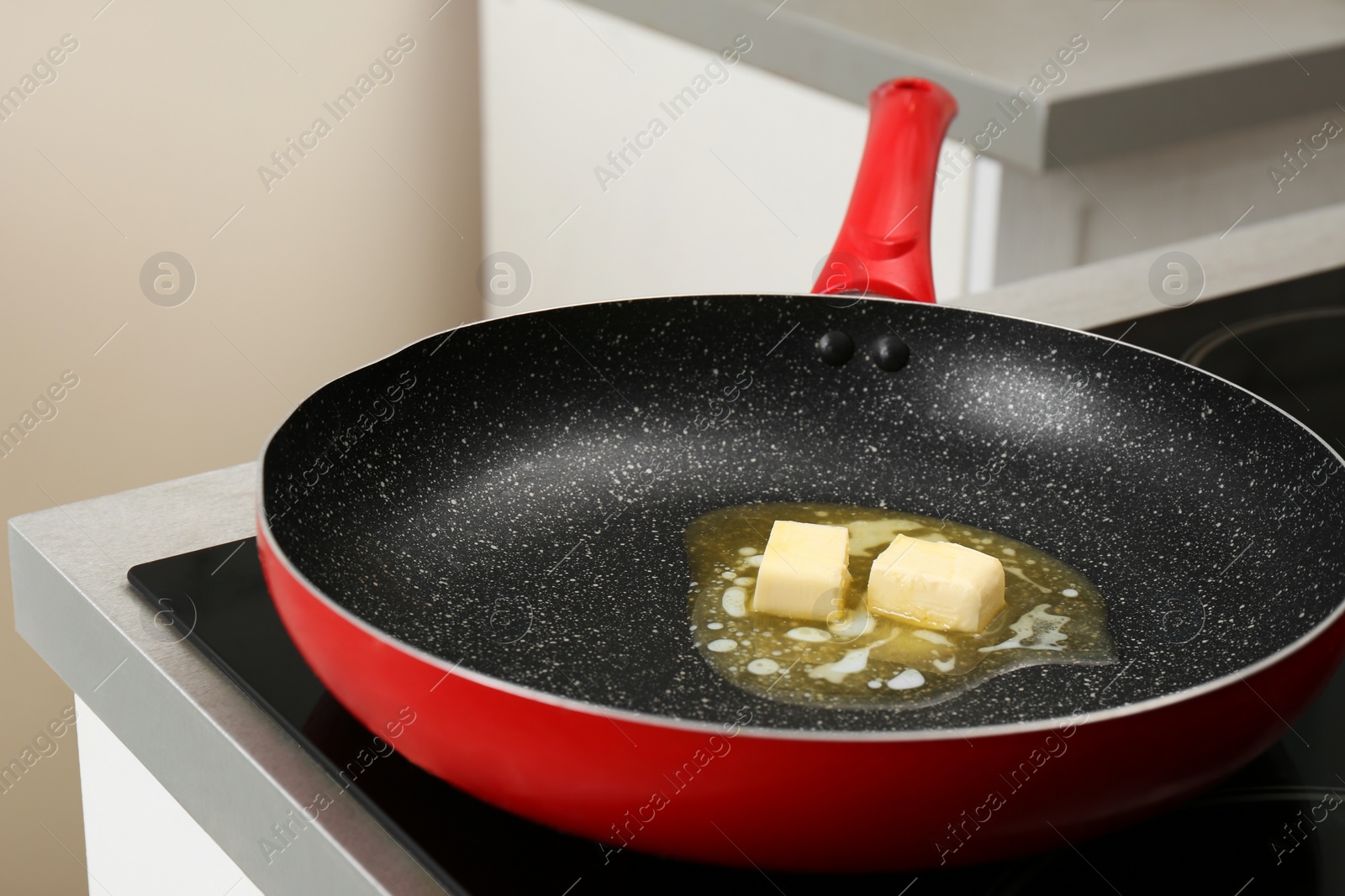 Photo of Frying pan with melting butter on electric stove