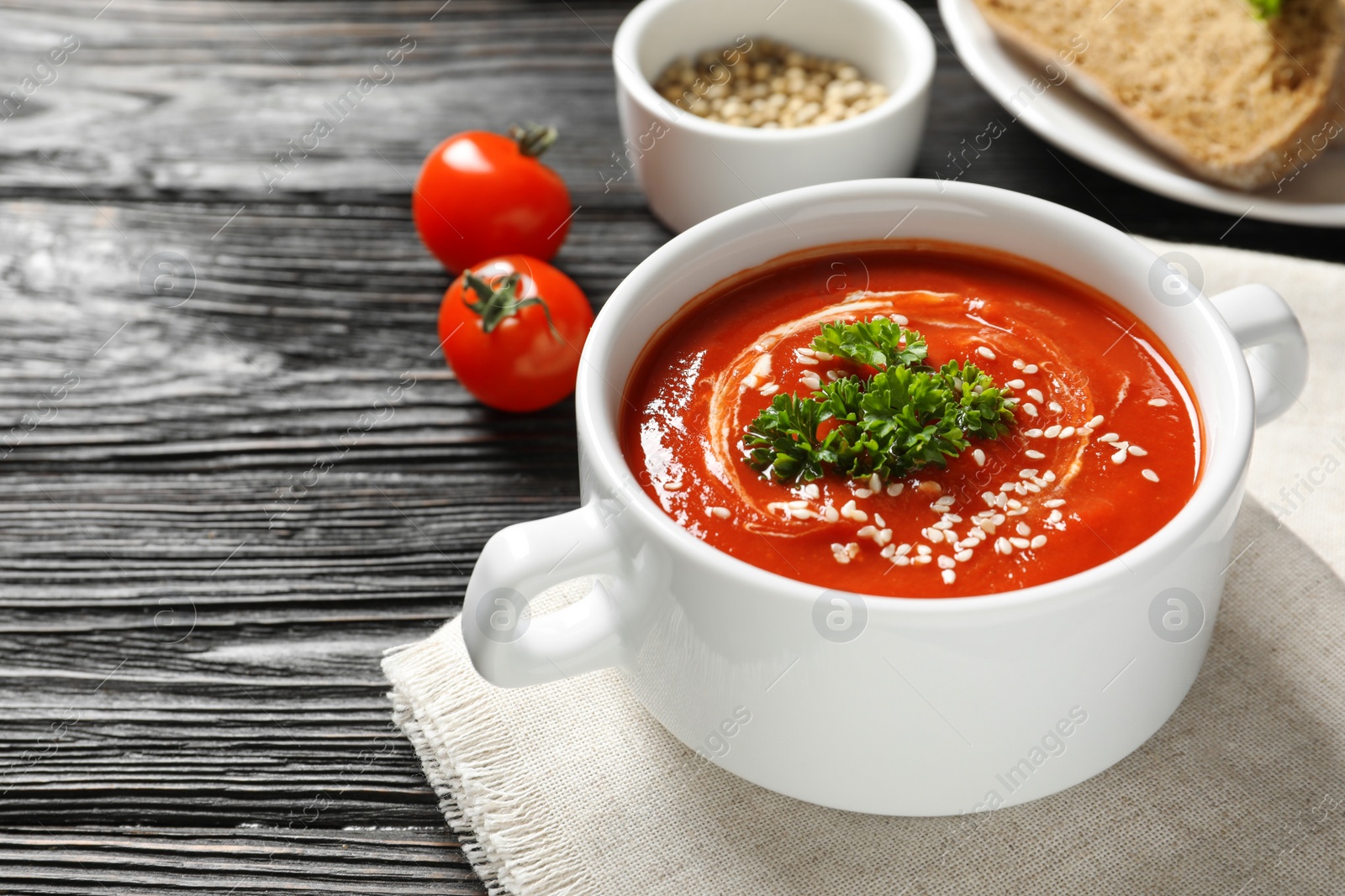 Photo of Dish with fresh homemade tomato soup and space for text on wooden table