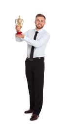 Photo of Full length portrait of happy young businessman with gold trophy cup on white background