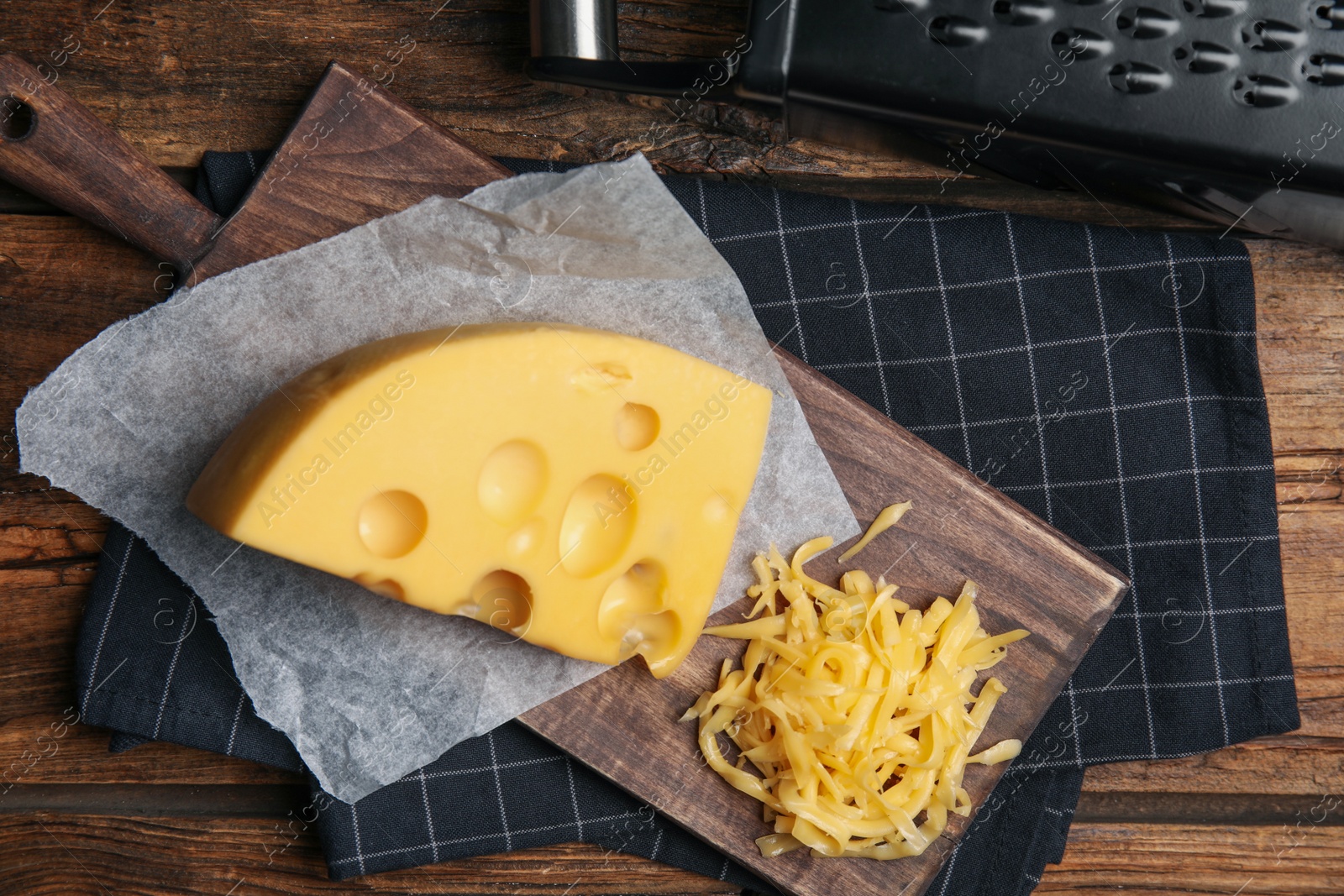 Photo of Tasty grated cheese on wooden table, flat lay