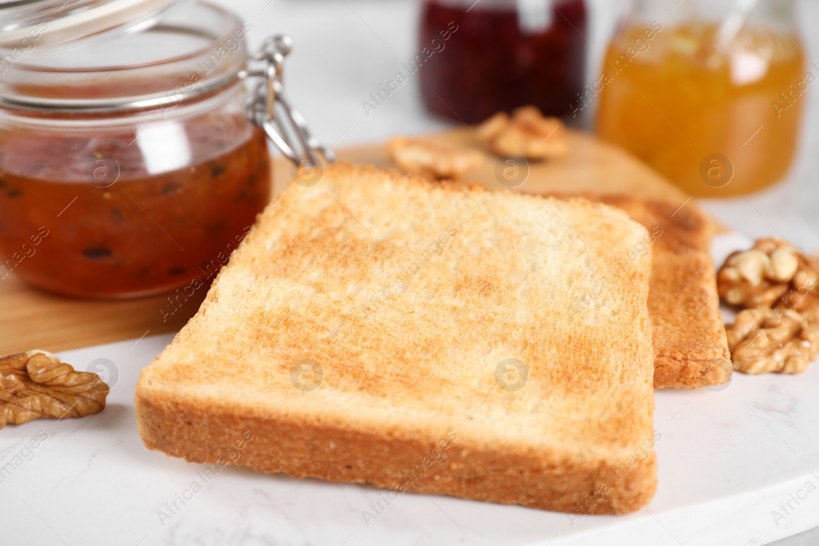 Image of Toasts, sea buckthorn jam and walnuts for breakfast on table, closeup