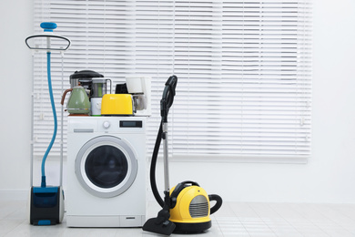 Photo of Different household appliances near window in room. Space for text