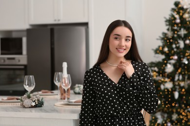 Happy woman near table served for Christmas in kitchen