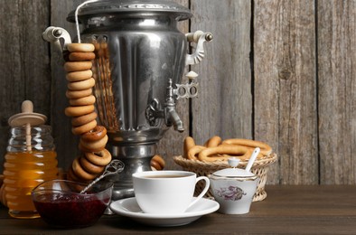 Photo of Composition with hot tea and delicious ring shaped Sushki (dry bagels) on wooden table, space for text