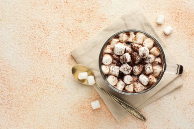 Photo of Cup of aromatic hot chocolate with marshmallows and cocoa powder served on beige table, flat lay. Space for text