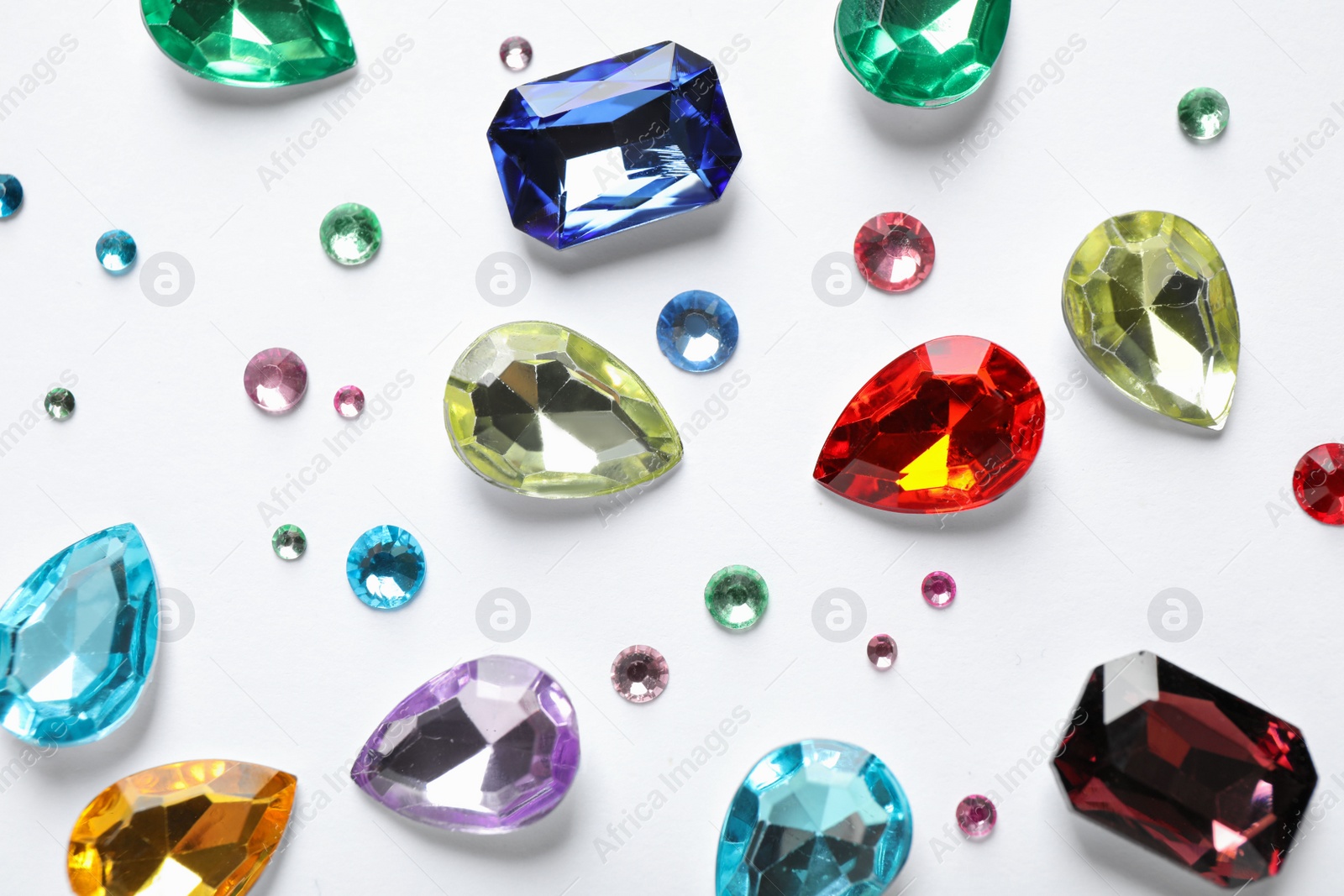 Photo of Different beautiful gemstones on white background, top view