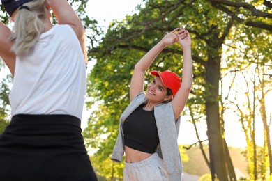 Women doing morning exercise in park on sunny day