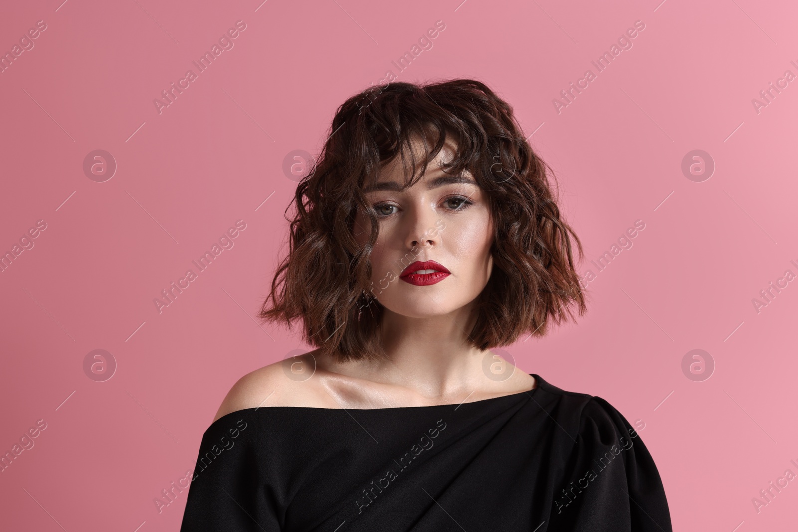 Photo of Portrait of beautiful young woman with wavy hairstyle on pink background