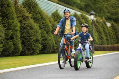 Dad and son riding modern bicycles outdoors