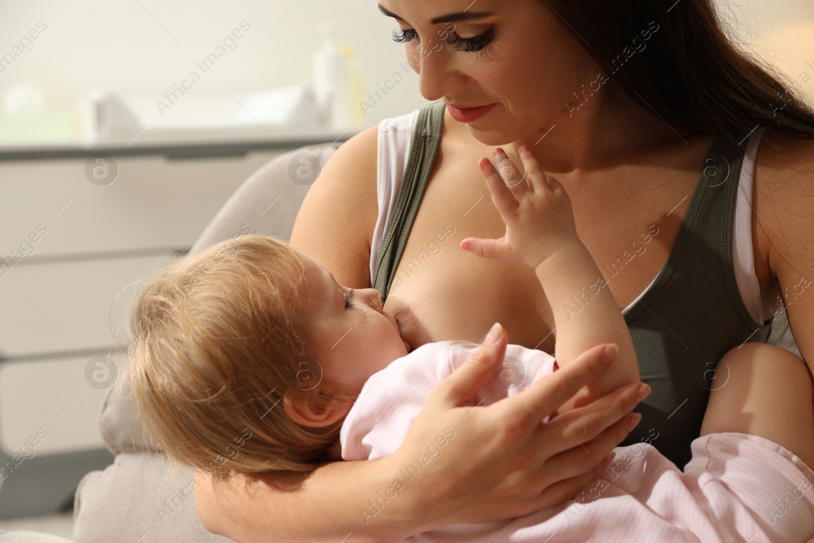 Photo of Woman breastfeeding her little baby at home