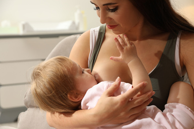 Woman breastfeeding her little baby at home