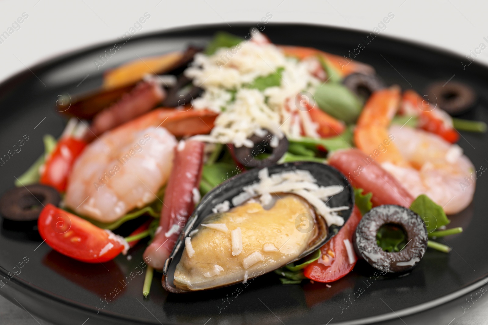 Photo of Plate of delicious salad with seafood, closeup view