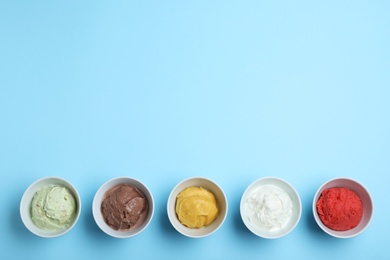 Different delicious ice creams on light blue background, flat lay. Space for text