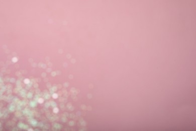 Blurred view of white glitter on pink background, space for text. Bokeh effect