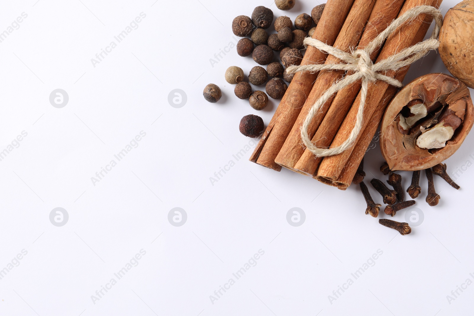 Photo of Different spices and nuts on white table, flat lay. Space for text