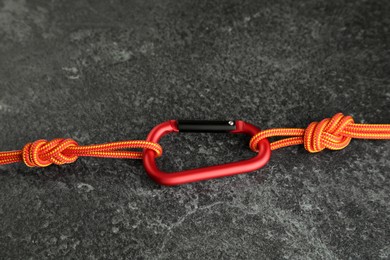 Photo of One metal carabiner with ropes on black table