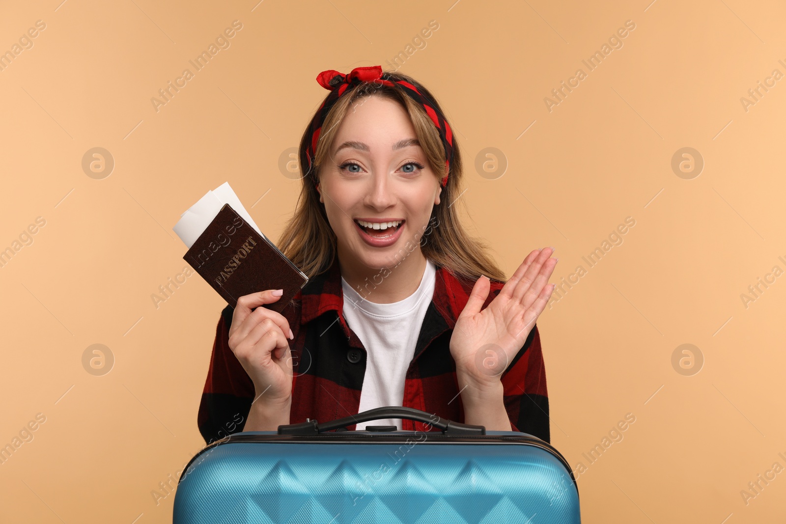 Photo of Emotional young woman with passport, ticket and suitcase on beige background