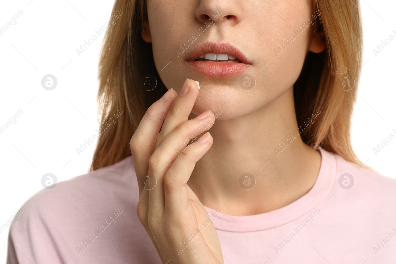 Photo of Woman with herpes applying cream onto lip against white background, closeup