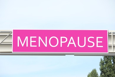 Image of Concept of impending climacteric. Pink sign with word MENOPAUSE outdoors