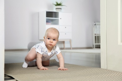 Cute little baby crawling on carpet indoors