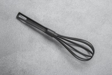 Plastic whisk on gray table, top view