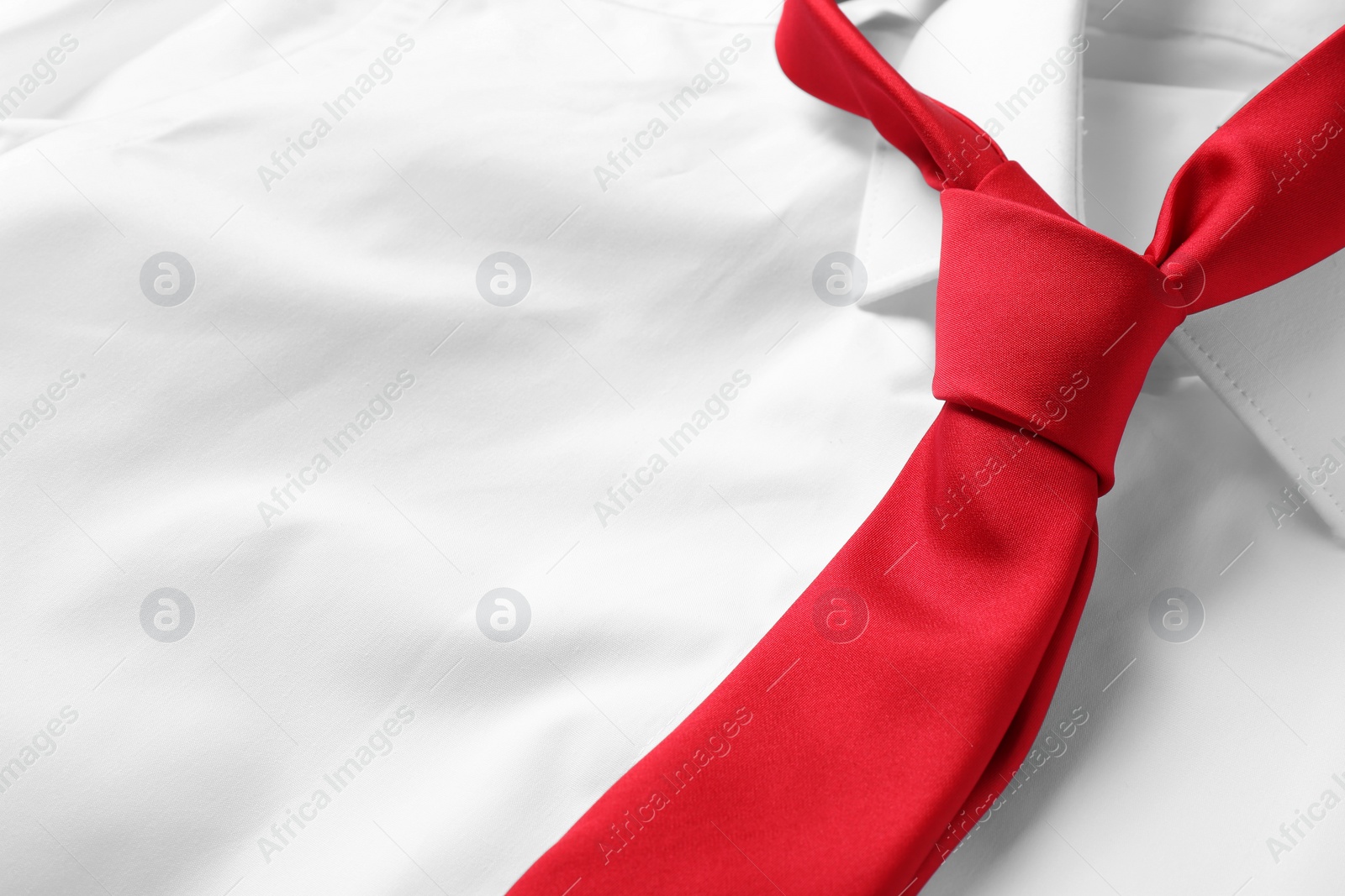 Photo of Red male necktie on white shirt, closeup. Space for text