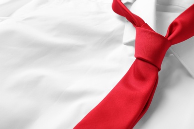 Red male necktie on white shirt, closeup. Space for text