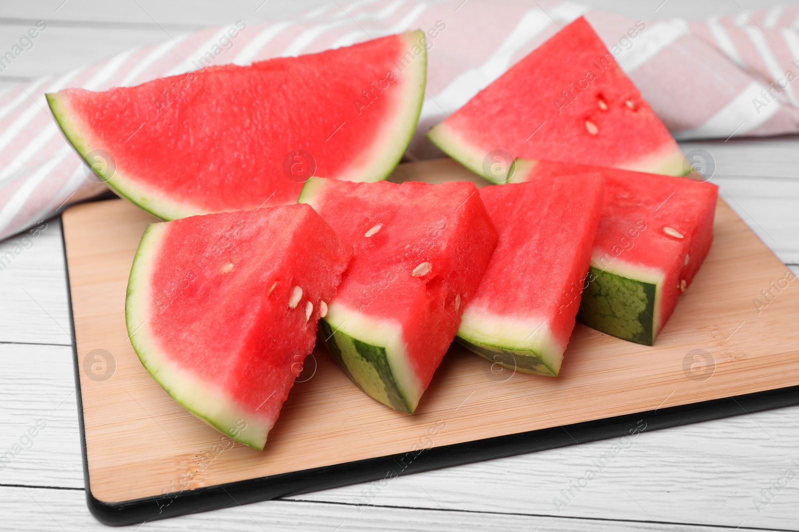 Photo of Pieces of juicy ripe watermelon on white wooden table, closeup