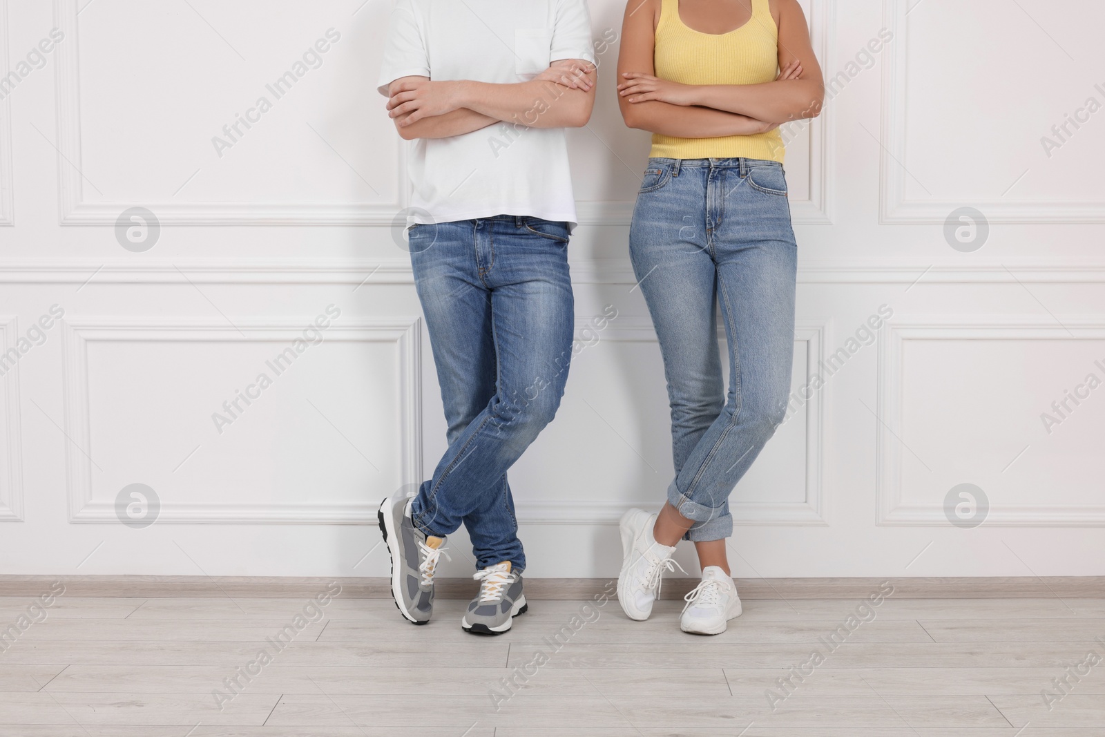 Photo of People in stylish jeans near white wall indoors, closeup