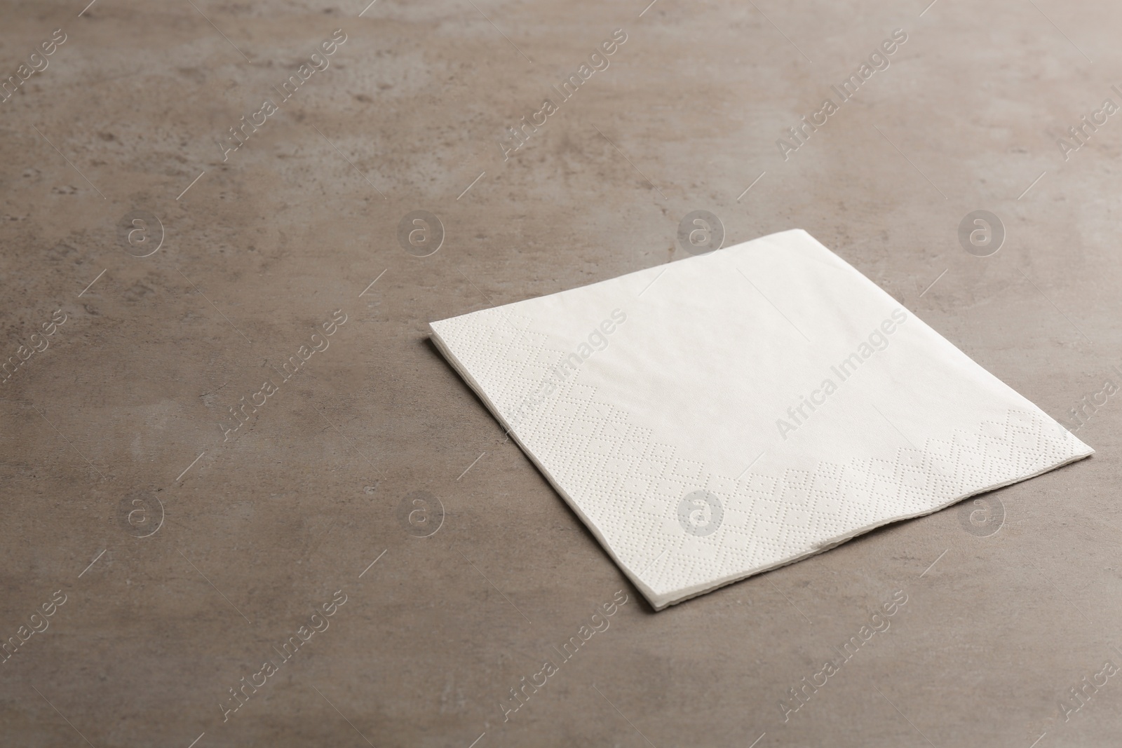 Photo of Clean paper napkin and space for text on grey background