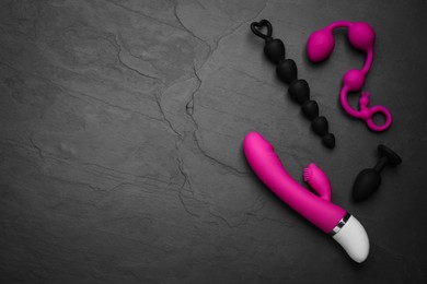Photo of Sex toys on black background, flat lay. Space for text