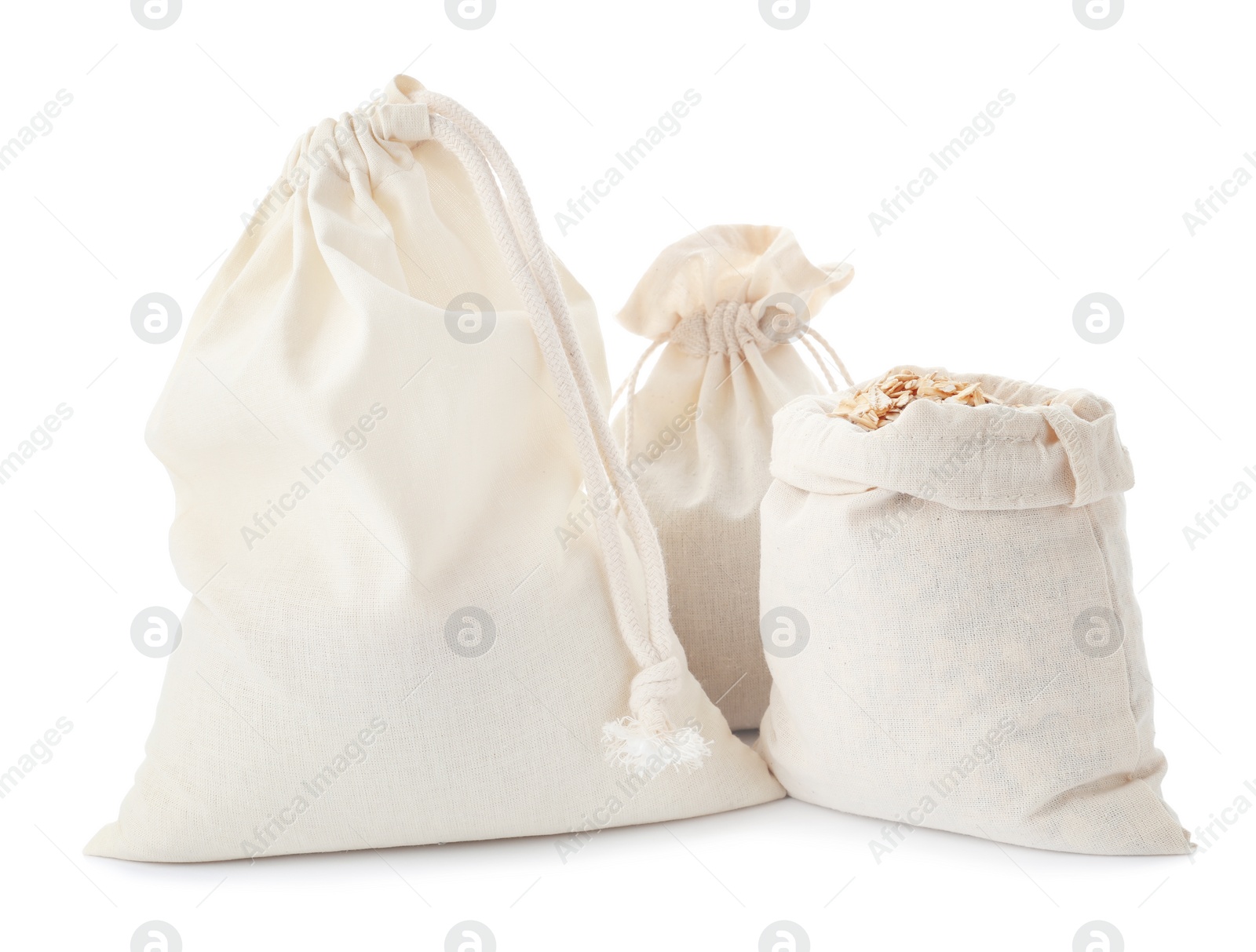 Photo of Cotton eco bags with oat flakes isolated on white